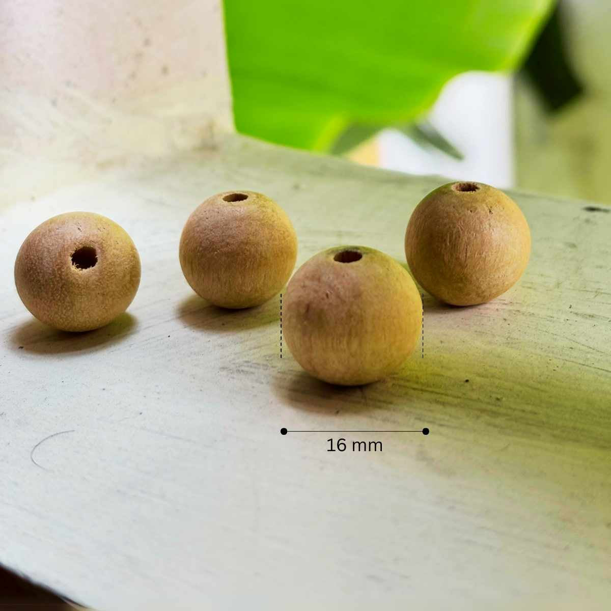 Four wooden beads with a measurement label indicating 16 mm, big and safe enough for toddlers