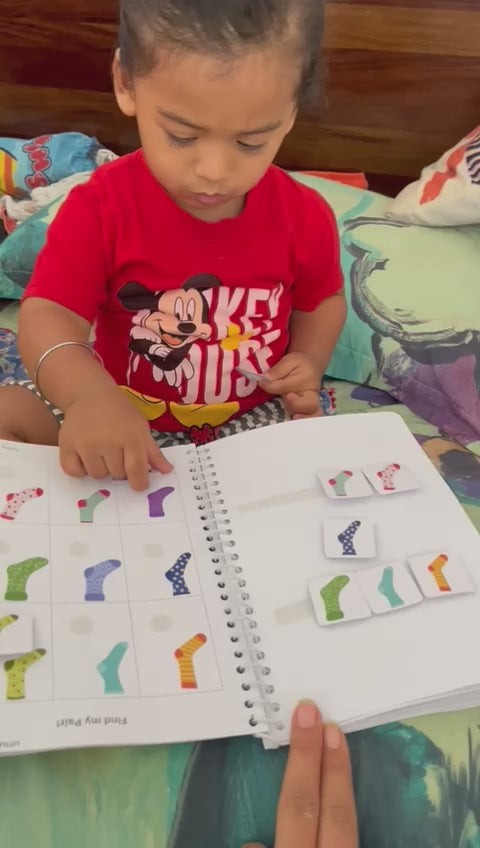 A kid with red T-shirt pairing the right socks with it's match on an activity sheet.